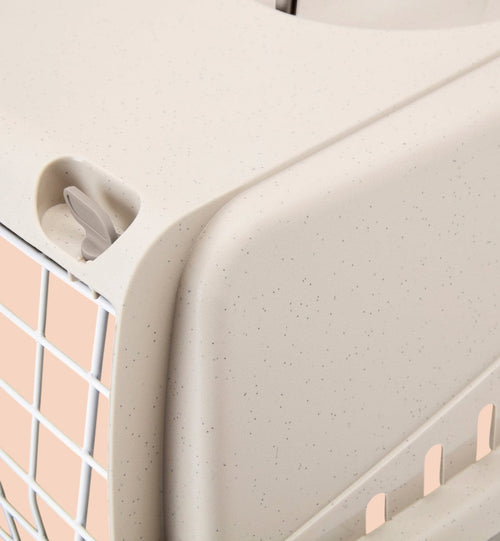 Cage de transport pour chat Animozen en plastique beige moucheté avec grille métallique et système de fermeture sécurisé.